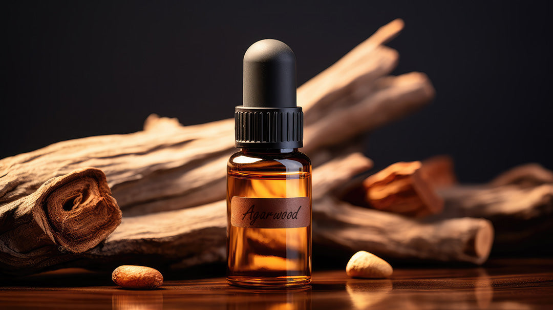 agarwood (oud) pieces next to vial of pure oud oil