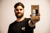 beard oil and beard wash held by a man